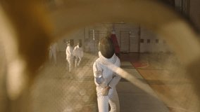 Duel, battle of two fencing athletes . Shot of the camera from inside the fencing mask . Two Professional Fencers Show Masterful Swordsmanship . Shot on ARRI ALEXA cinema camera .