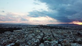 Aerial drone bird's eye video of Athens and iconic Acropolis hill as seen from Lycabettus at dusk, Athens historic center, Attica, Greece