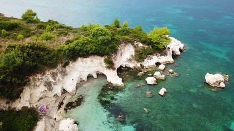 Aerial drone video of volcanic beach of Kalamia with white rock formations and turquoise beach with sun beds, Argostoli, Cefalonia, Greece