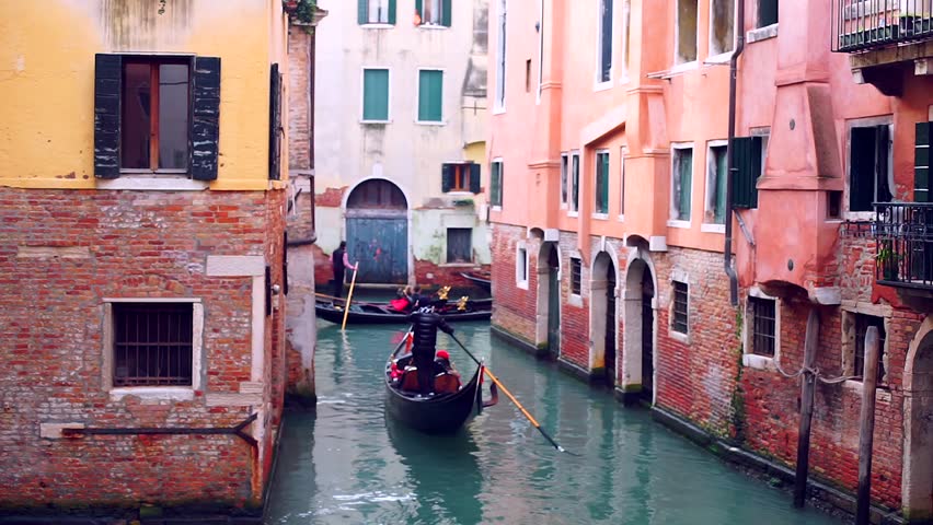 Gondoliers lined up in single line navigating the gondolas with tourists through the narrow canal in Venice Italy during winter