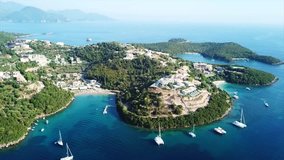 Aerial bird's eye view video taken by drone of boat in tropical paradise seascape of Sivota complex islands with turquoise and sapphire clear water sandy beaches, Ionian, Epirus, Greece