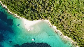 Aerial drone bird's eye view video of iconic paradise sandy beach of blue lagoon with deep turquoise clear sea and pine trees in complex island of Mourtos in Sivota area, Ionian, Epirus, Greece