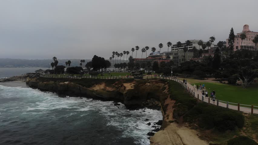 eautiful Drone Views Facing California La Jolla Coastline, Cliff Side and Cove, People Walking Along Shoreline, Beautiful Dark Beaches 