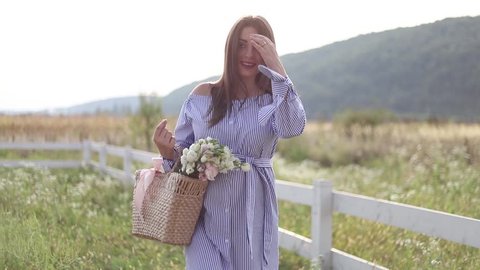 Attractive pregnant woman poses to camera and smile. Woman stand in nature and walking thought field near the farm. slow motion HD