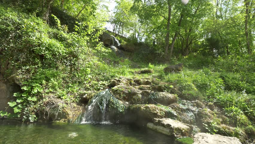 Pond and Rock Fountain in Lush Green Midwestern Park, Slow Motion