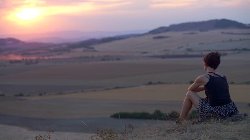 Young woman meditation sits back on hill and looks into the distance of the mountain. Nature wild life and human. Mindfulness and stress reduction, finding solace in natural surroundings sunset space Royalty-Free Stock Footage #1017248749