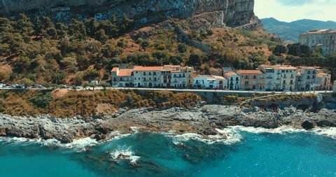 Aerial view of rocky shores with old houses, cathedral in historic seaside town of Cefalu, Sicily, Italy .