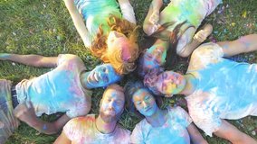 Group of friends having fun in a park playing with holi colored dust.