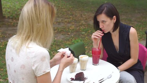 two girls are sitting at a table on a mid-afternoon snack, drink latte and  lemonade with drinking straw.
Environmental threat concept.