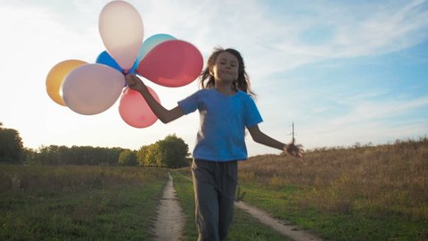 Happy child with balloons on nature.