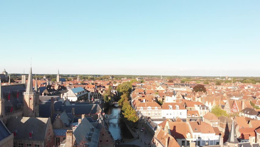 Aerial view of the streets of Bruges, Belgium flying over a river in the center of the city