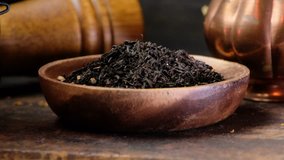 Dried loose black tea leaves in wooden bowl.