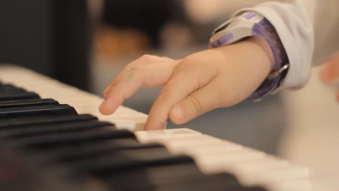 Close up of two child's small hands playing piano