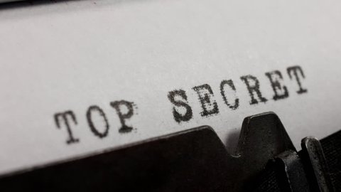 Typing TOP SECRET in black ink on an old mechanical typewriter.