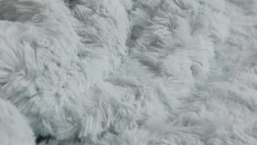 Close-up of blue artificial hairy fur blanket 4K tilting video