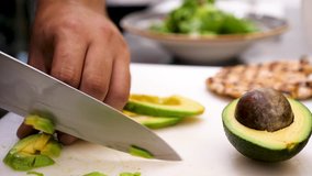 Cutting an avocado in pieces. Close up footage