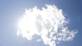 Very beautiful clear blue sky & rolling, formating white clouds with sun rays shining, nice summer day, Sunny light in  fast motion clouds. Time lapse footage. FHD.