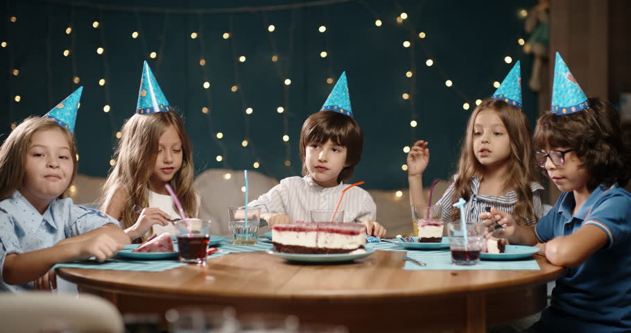 Kids eating birthday cake. Little multiethnic friends celebrating, having fun on a birthday party - happy childhood concept 4k