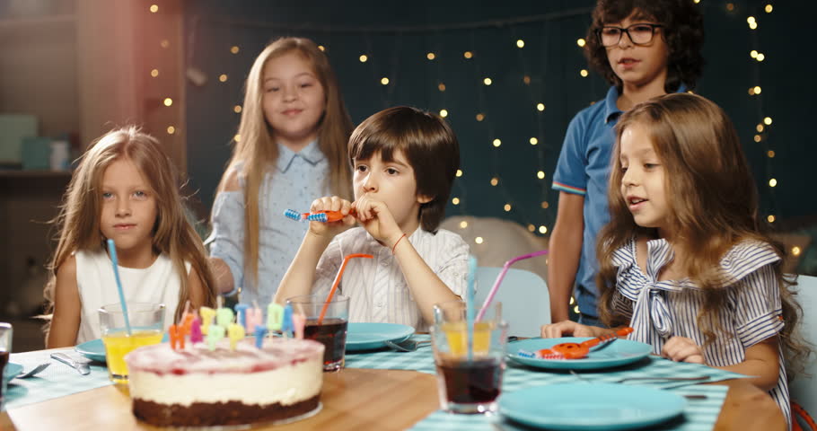Children having birthday party. Group of kids celebraing birthday of their friend, cheering, having fun - happy childhood concept 4k