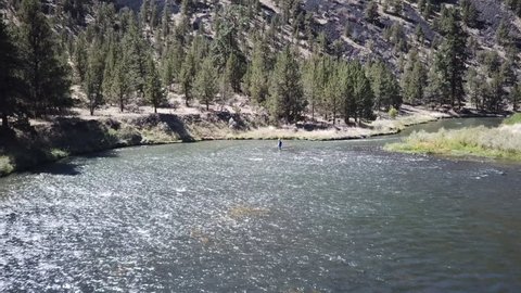 Flight over flyfisherman in the high desert of central Oregon over premier flyfishing trout stream in the crooked river canyon