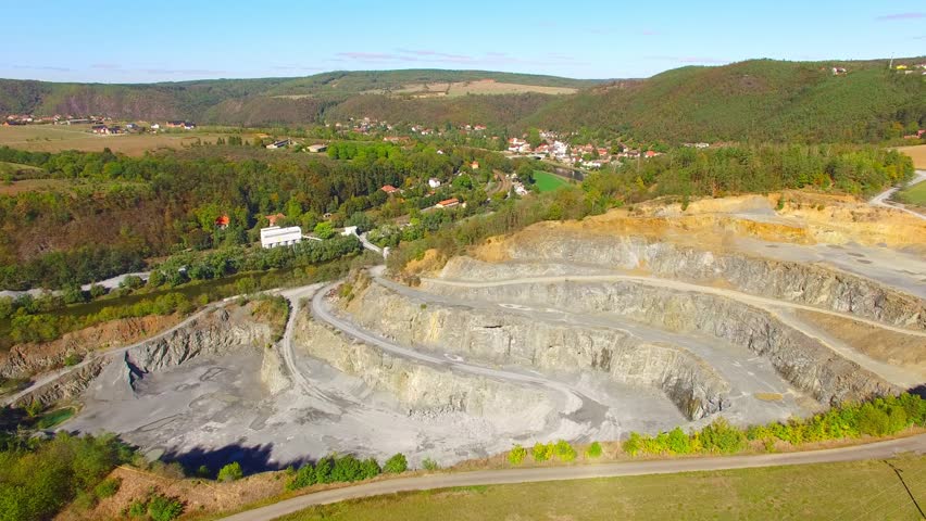 Camera flight over a stone quarry on Berounka river near Zbecno.  Industrial landscape in Czech Republic. Heavy industry from above. 
