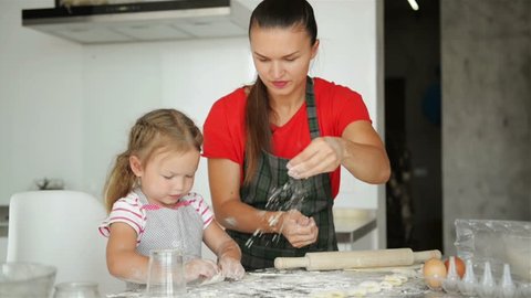 Happy Loving Family Are Preparing Bakery Together. Mother And Child Daughter Girl Are Cooking Cookies And Having Fun In The Kitchen. Homemade Food And Little Helper.