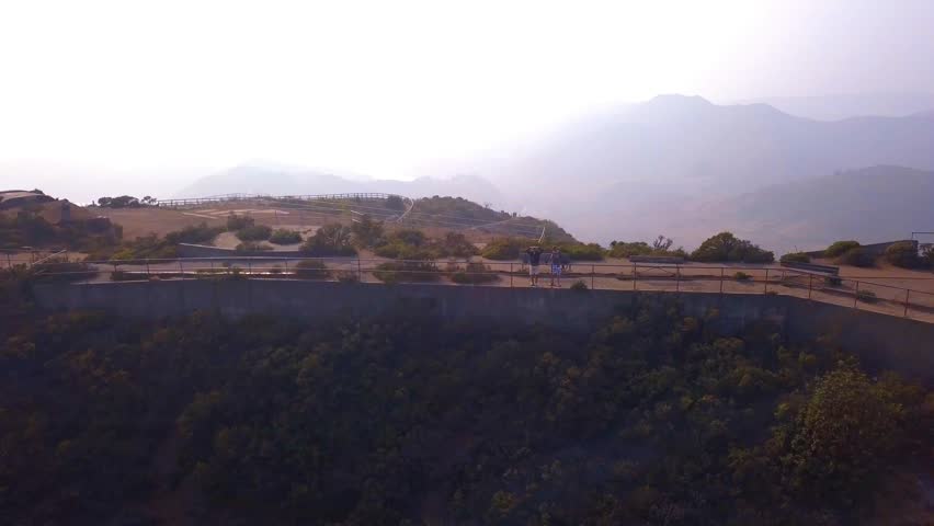 Young people standing on the edge of the cliff near San Francisco looking onto the Golden gate bridge.