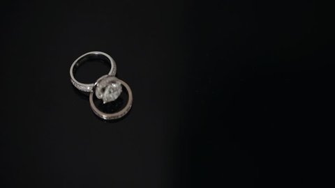 Shot Of Two Wedding Rings At The Black Background. Composition Of Two Wedding Rings At The Table.