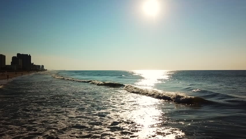 Incredible view of waves at Myrtle beach in SC. The sun shining over the coast with some beautiful colors.