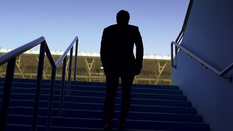 Businessman walking in Empty seats in a stadium