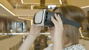 Curious amazed woman takes off VR helmet.