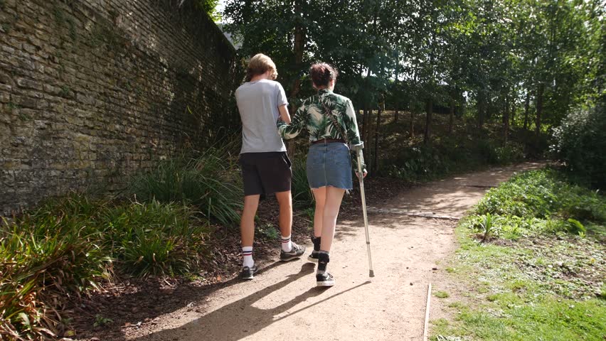 Disabled Woman and Man Walking in a Park