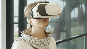 Curious amazed woman trying augmented reality glasses, feeling excited about VR headset simulation, exploring virtual life by gesturing hands to touch 3d world, having fun with goggles.