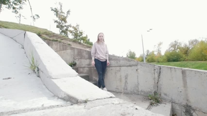 Young acrobatic girl jumps over the barrier. Slow motion