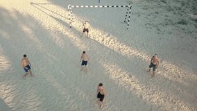 Sport Soccer players in dynamic action funny play on the sand in beach football in summer sunny day under sunlight. Aerial View, Drone 4K Video