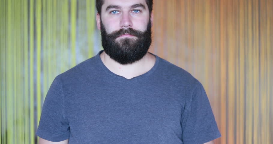Portrait of skinny man cheerfully touching his mustaches. Handsome gentleman smiling sincerely with white teeth on camera closeup. Concept of emotions