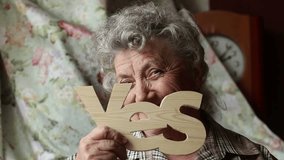 Elderly smile and thoughtful woman with wood word "Yes" - Powered by Shutterstock - Get 15% off with code: PIKWIZARD15