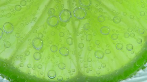 Fresh lemon in soda water covered with bubbles