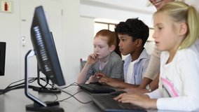 Teacher helping multiethnic children at computer terminal in primary school. Smiling school children looking at computer screen with teacher in library. Computer class at elementary school. - Powered by Shutterstock - Get 15% off with code: PIKWIZARD15