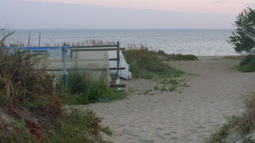 Hand made pen on sea shore. View during sunrise