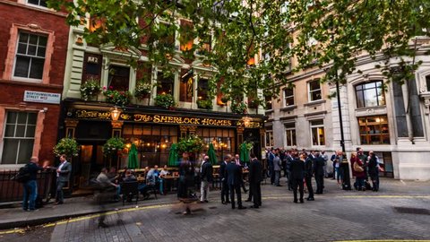 LONDON / UK - SEPTEMBER 20, 2018: Timelapse view of people drinking and chatting outside a traditional pub in london