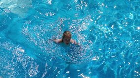 Girl swiming in the swiming pool, top view slow motion video