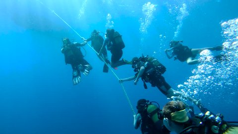 KAS, TURKEY - SEP 19: Group of scuba divers slowly ascending on anchor line on September 19, 2018 in Kas, Turkey