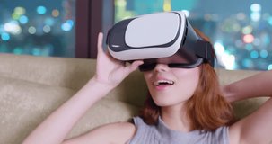 woman sit on sofa and wear virtual reality headset watch 3d movie at home