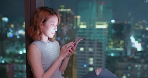 woman use phone happily in building at night