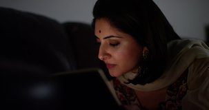 4K Young Indian woman browsing the web late at night, reacting with interest & surprise