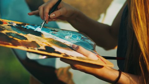 Woman hand mixing oil paints on wooden palette. Creative artist painting picture. Close up female hand with paintbrush : vidéo de stock