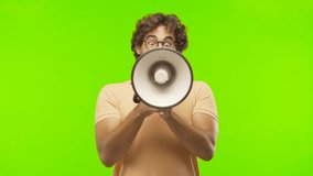 young bearded silly man shouting with a megaphone against chroma key editable background. ready to cut out the person.