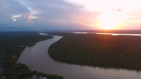 Flying over Mana river Guiana Suriname during sunset. Amazonian forest 