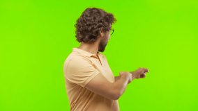 young bearded silly man pointing something against chroma key editable background. ready to cut out the person.